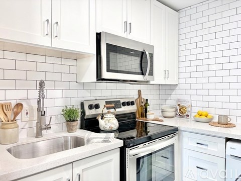 A white kitchen with a stove, oven, microwave, and dishwasher.