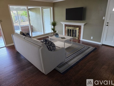 A living room with a white couch and a fireplace.