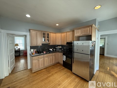 A kitchen with wooden cabinets and a stainless steel refrigerator.