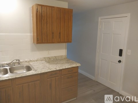 A kitchen with wooden cabinets and a white door.