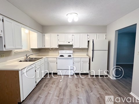 A kitchen with white cabinets and a wooden island.