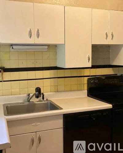 A kitchen with white cabinets and a black oven.