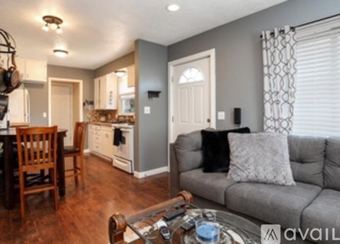 A living room with a grey couch and a wooden coffee table.