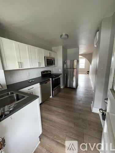 A kitchen with white cabinets and a grey counter top.