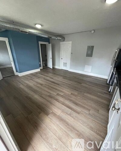 A room with wooden flooring and white walls.