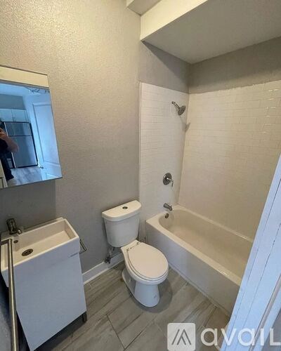 A white toilet sits next to a bathtub in a bathroom.