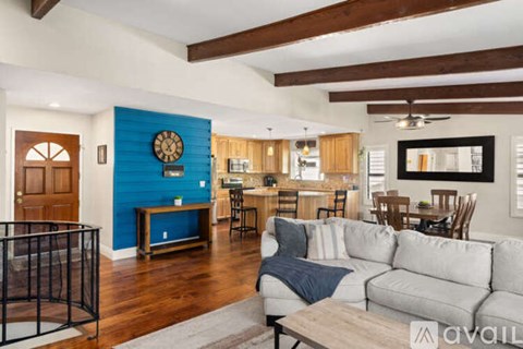 A living room with a grey couch and a wooden floor.