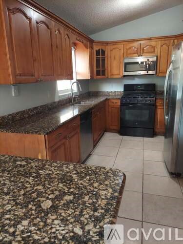 A kitchen with wooden cabinets and granite countertops.
