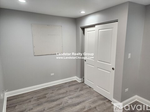 A room with a door and a whiteboard on the wall.