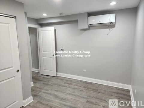 A room with a door and an air conditioner unit on the wall.