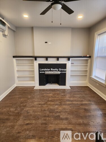 A room with a wooden floor and a fan on the ceiling.