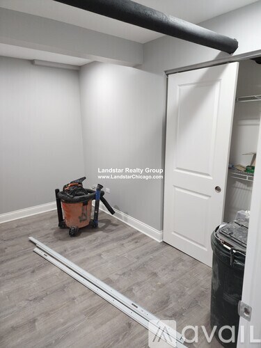 A room with a white door and a black pipe on the ceiling.