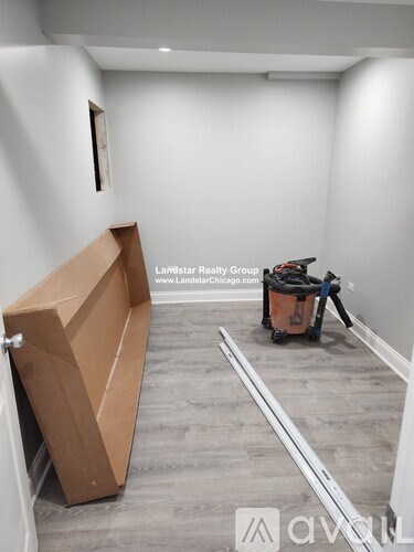 A room with a large cardboard box on the floor.