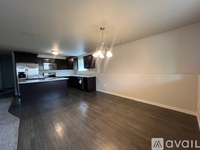 A kitchen with a refrigerator, microwave, and oven.