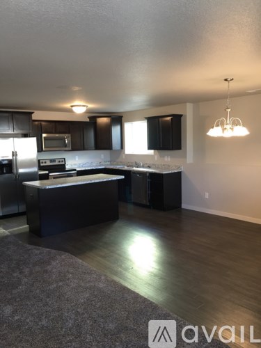 A kitchen with a refrigerator, microwave, and oven.