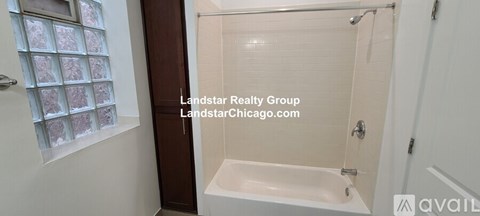 A white bathtub with a glass shower door in a bathroom.