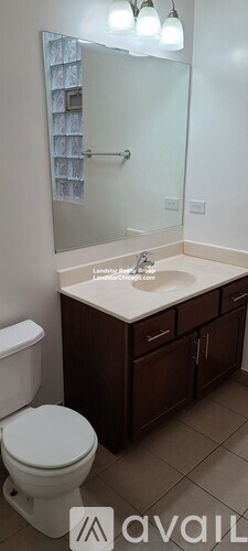 A bathroom with a toilet, sink, and mirror.