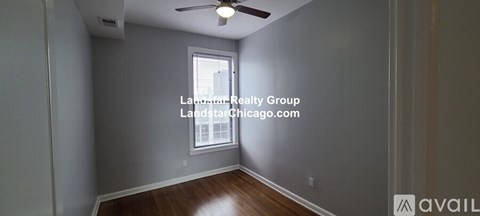 A room with a window and a fan on the ceiling.