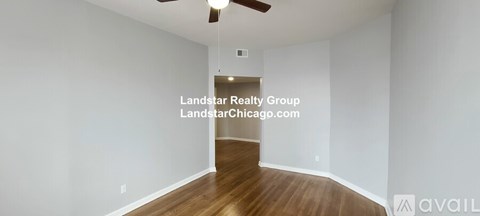 A room with a wooden floor and a ceiling fan.