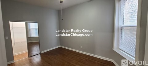 A room with a door and a window with blinds.