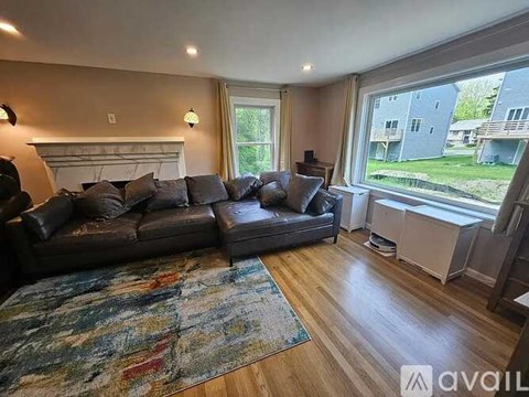 A living room with a large couch and a fireplace.