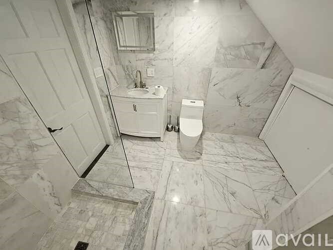 A bathroom with marble flooring and a white cabinet.