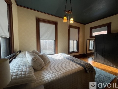 A bedroom with a large bed and a ceiling fan.