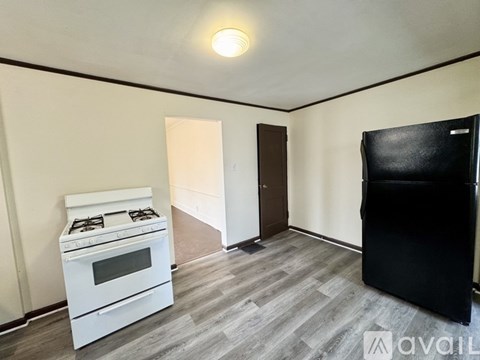 A kitchen with a white stove and a black refrigerator.
