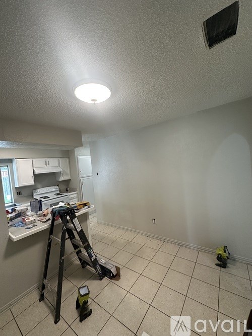 A room with a white ceiling and a white wall with a black square on it.