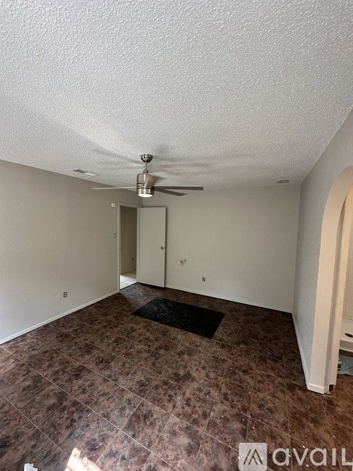 A room with a ceiling fan and a door.