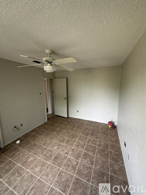 A room with a ceiling fan and tile flooring.