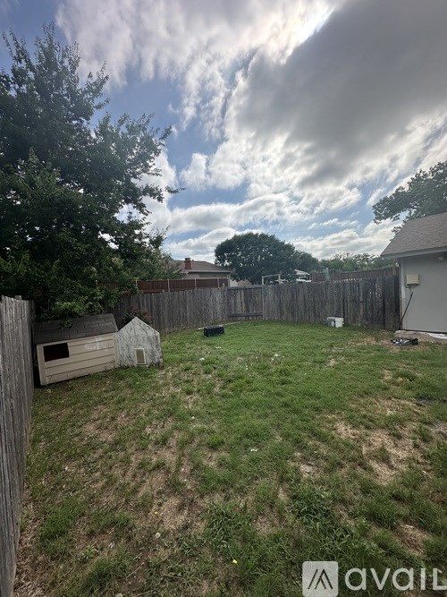 A backyard with a wooden fence and a shed.