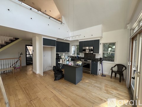 A kitchen with a wooden floor and a dining area with a chair.