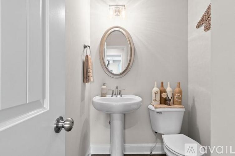 A bathroom with a white toilet, sink, and a mirror.