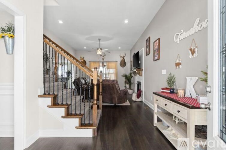 A hallway with a staircase and a bench with a sign that says "K" on it.