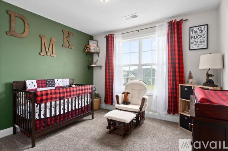 A baby room with a crib, chair, and a poster on the wall.
