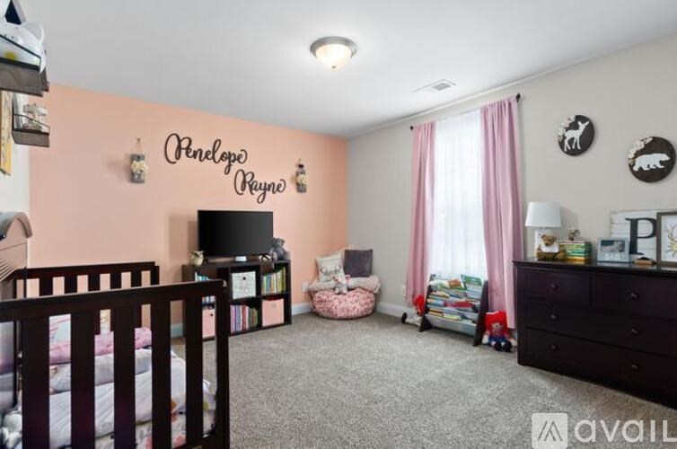 A baby's room with a pink wall and a white crib.