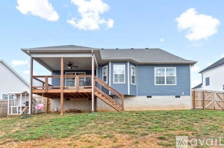 A blue house with a covered patio and a deck.