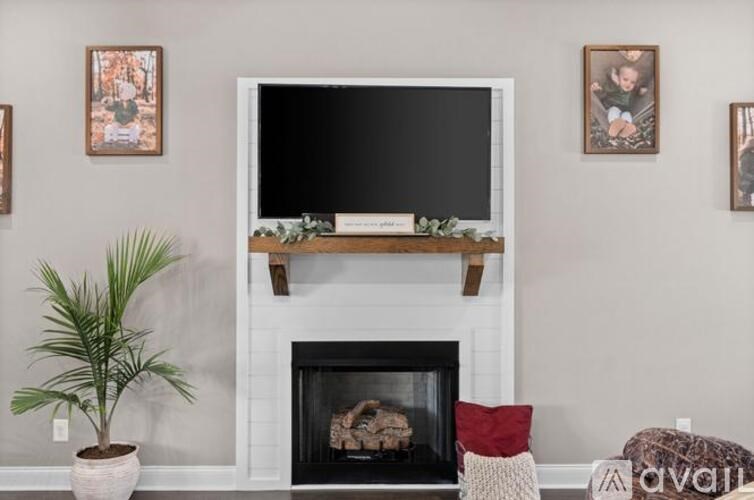 A living room with a fireplace and a flat screen TV mounted above it.