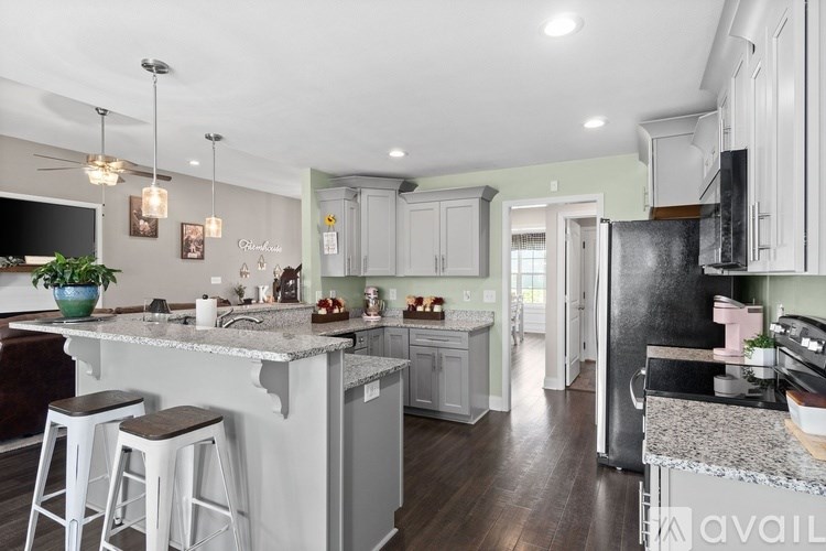 A kitchen with a granite countertop and white cabinets.
