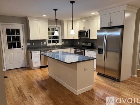 A kitchen with a granite countertop and stainless steel appliances.