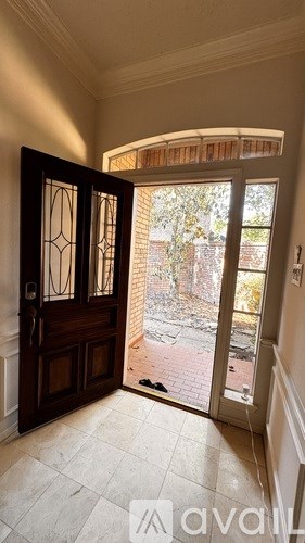A room with a wooden door and a glass window leading to a balcony.