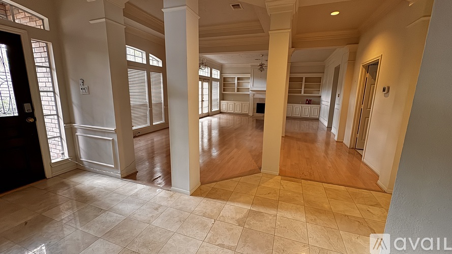 A spacious room with a tiled floor and a series of columns.