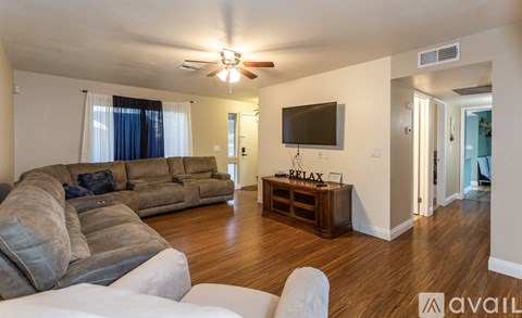 A living room with a grey sofa and a wooden table with a sign that says "RELAX".