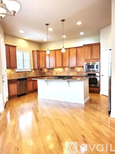 A kitchen with wooden cabinets and a white island.
