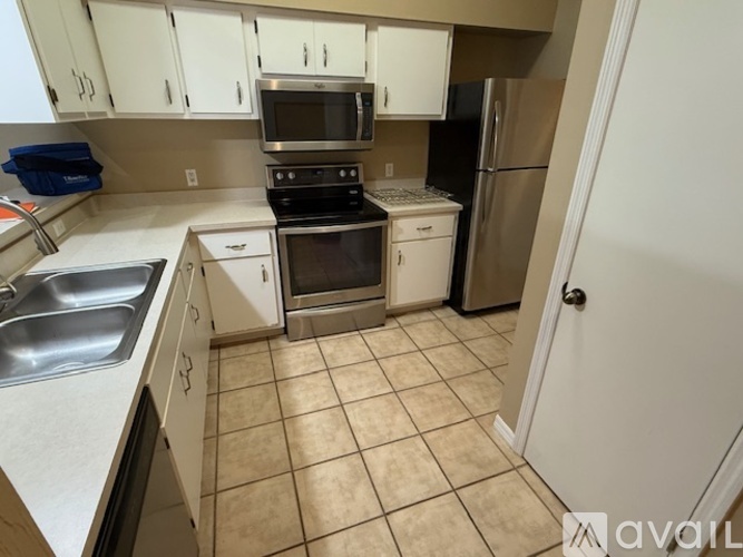 A kitchen with white cabinets and appliances.