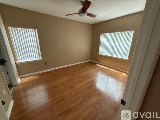 A room with wooden flooring and a ceiling fan.