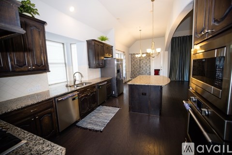 A kitchen with dark wood cabinets and stainless steel appliances.