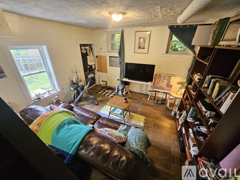 A living room with a brown leather couch and a fireplace.
