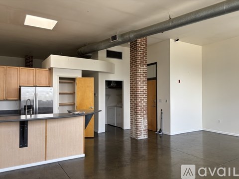 A kitchen with wooden cabinets and a brick pillar.